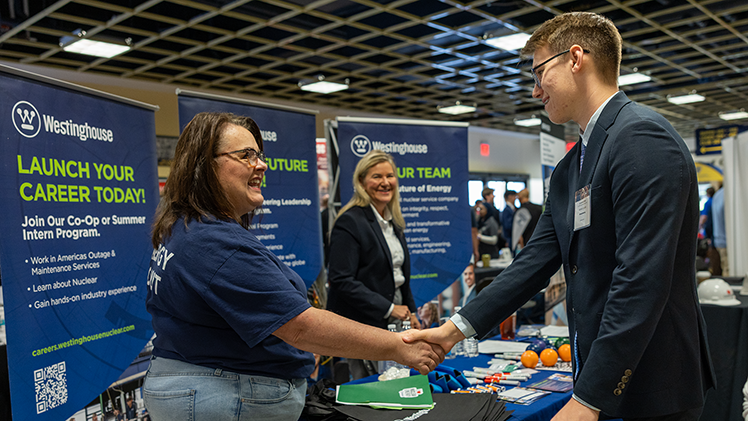 Nathan Coulter, right, a sophomore in bioengineering, shakes hands with Westinghouse representative Amy Cremomese at Thursday’s Fall Engineering Career Expo in Savage Arena.