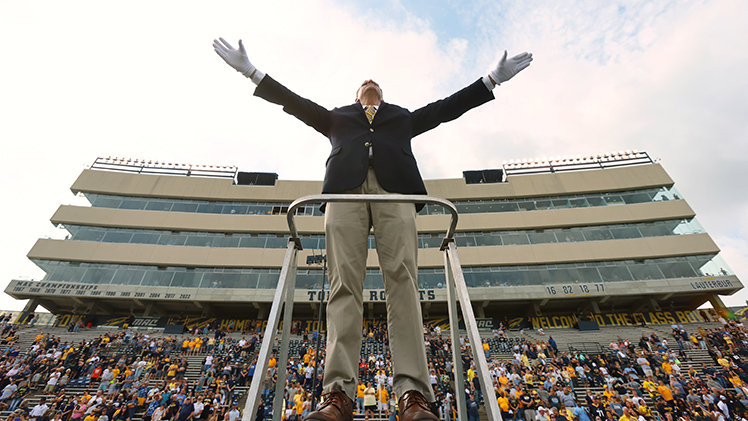Dr. Andrew Rhodes, director of athletic bands, conducts the Rocket Marching Band during a performance of the alma mater “Fair Toledo” as part of the pre-game festivities.