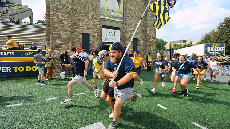 Photo of the annual student run onto the field at Glass Bowl Stadium prior to kickoff as part of the home-opener pregame festivities.