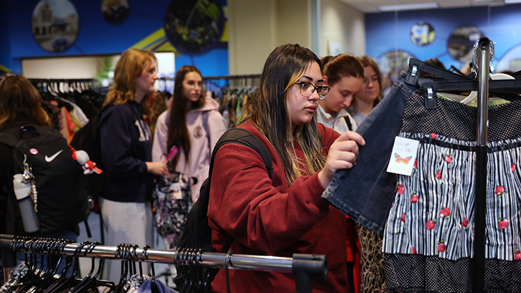 Sophomore criminal justice major Olivia Palmer browses the Vintage Market's clothing selections.