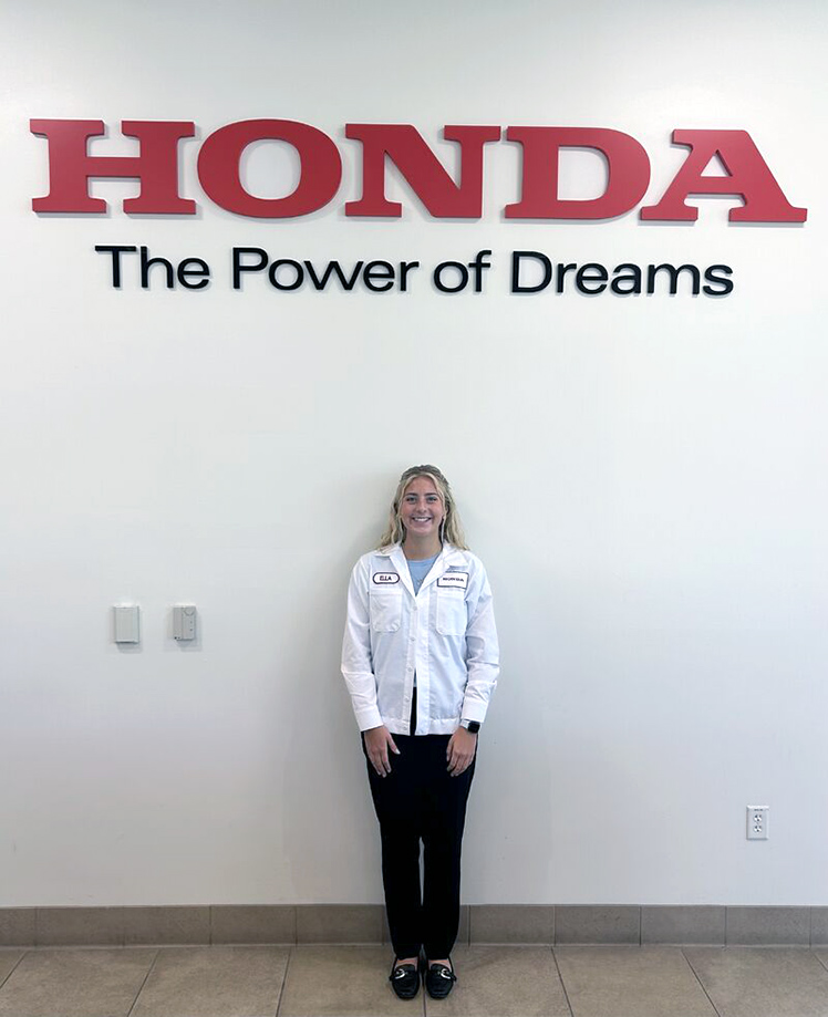 UToledo student Ella Boerger poses in front of a Honda sign during her internship with the company.