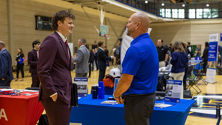 Grant Poeppelman, a junior in finance, speaks with Jason Heaster, a company representative from Fastenal.