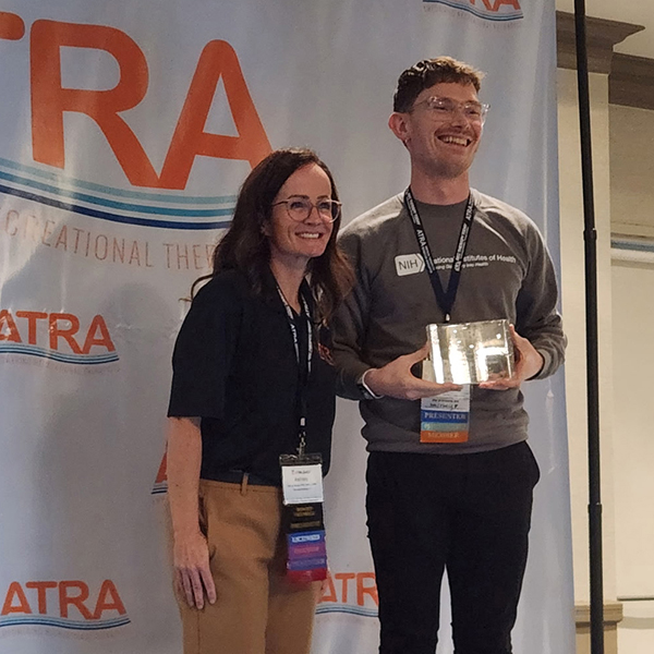 Stefan Ellington, a 2019 UToledo recreational therapy graduate, accepts the National Excellence in Education Award on the University's behalf at the 2026 ATRA Annual Conference held on Oct 17.